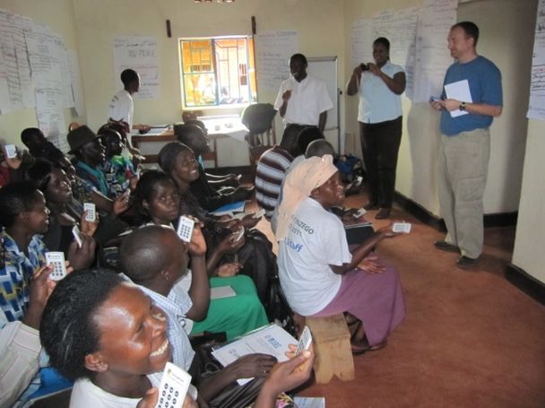 Photo of Rwandan students in classroom using their clickers as part of classroom activity