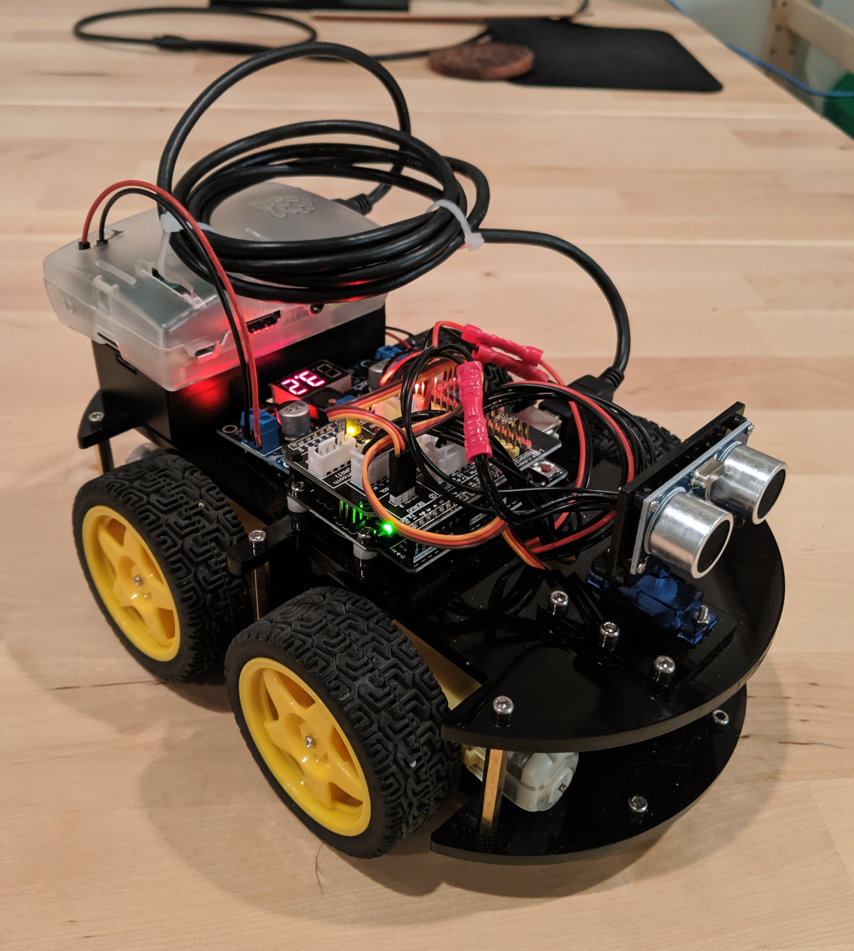The small robot resembles a car, with large wheels and many wires protruding from the top