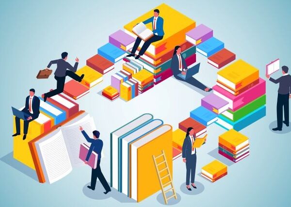 Stacks of multicolored books form a maze, with adult workers, dressed in suits, navigating up, down, and around them.