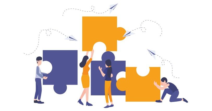 Four figures dressed in purple and gold cooperate to align four puzzle pieces, also purple and gold, against a white background with paper airplanes flying overhead