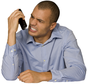 A man in a blue button-down shirt grimaces at his phone, which is in his right hand.