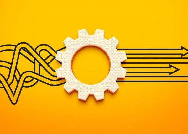 Against an orange background, a tangle of black lines runs through a gear, representing process, emerging as straight arrows pointing forward