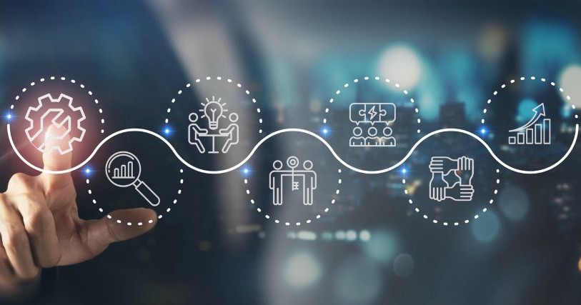 A hand points to one of a series of circles sitting on a wavy line against a blue background; each circle contains an icon representing a challenge: connection, learning, technology, etc.